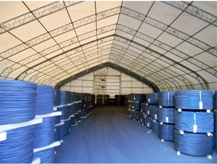 An indoor warehouse with stacked coils of blue wire.